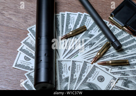 Rifle barrel, Unterdrücker und Patronen auf den Dollar. Konzept für Kriminalität, Mord, Mörder, Terrorismus, Krieg, globalen Waffenhandel, Waffen Stockfoto