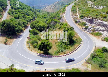 Luftbild einer Bergstraße mit Verkehr auf einer Hufeisenkurve. Stockfoto