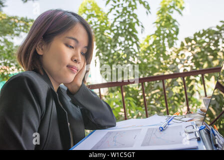 Büro Frau im schwarzen Anzug lesen finanzielle Anzahl auf Dokument Stockfoto
