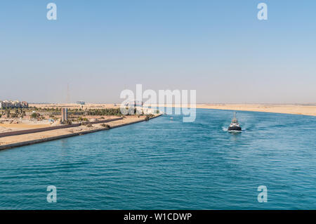 Suez, Ägypten - November 5, 2017: Große Containerschiffe (Schiffe), Suez Kanal in der Nähe von Suez, Ägypten, Afrika. Tugboat begleitet Schiffe in der foregrou Stockfoto