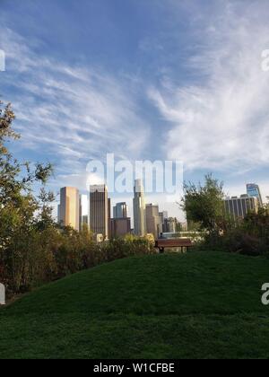 Spektakuläre Aussicht auf die Innenstadt von Los Angeles von einem grünen Park mit einem Hügel und einer Sitzbank, Vista Hermosa National Park. Stockfoto