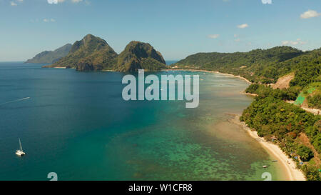 Antenne Drohne von tropischen Strand auf dem Hintergrund der Berge. Marine mit Blick auf das Meer, den Sand, Palmen. Corong corong Beach, El Nido, Palawan, Philippinen. Sommer und Reisen Urlaub Begriff Stockfoto