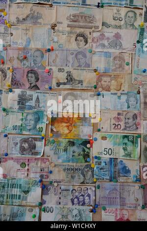 Sammlung verschiedener Banknoten aus einer Vielzahl von Ländern auf einem Aushang angeheftet. Stockfoto