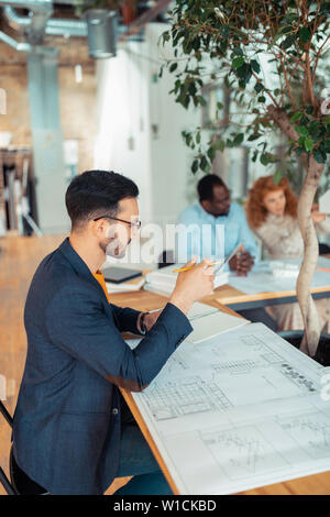 Man Skizzen. Dunkle bärtigen Haaren Interior Designer Jacke tragen, Skizzen Stockfoto