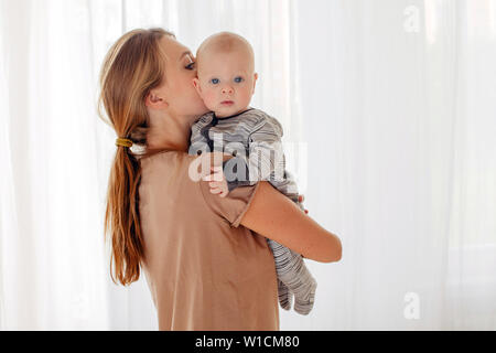 Mutter küssen und umarmen Baby Stockfoto