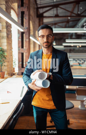 Erfahrene Designer. Erfahrene Innenarchitekten stehen in geräumigen Büro Skizzen Holding Stockfoto