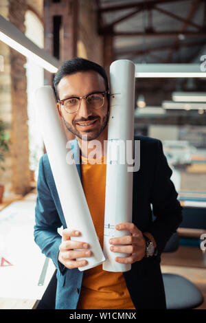 Designer Jacke tragen. Bärtige stattlichen Interior Designer Jacke tragen, stehen in geräumigen Büro Stockfoto