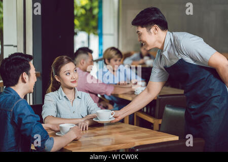 Kellner servieren Kaffee junge Frau im Cafe Stockfoto