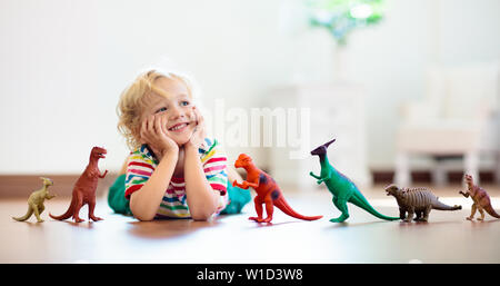 Kind spielt mit bunten Spielzeug Dinosaurier. Pädagogisches Spielzeug für Kinder. Kleiner Junge, der Fossilien und Reptilien lernt. Kinder spielen mit Dinosaurierspielzeug. Stockfoto