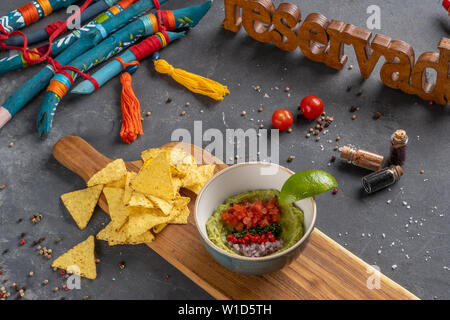 Avocado dip Guacamole mit Tortillachips auf Holz Schneidebrett auf Stein Hintergrund. nationale mexikanische Sauce. Nicht-Zutaten Stockfoto