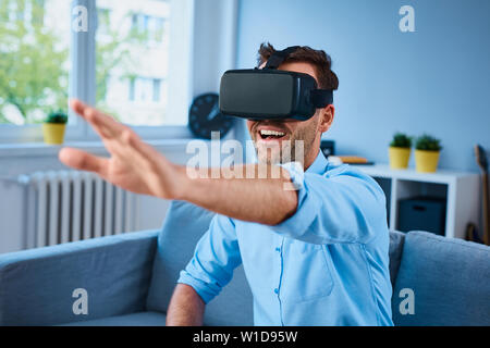 Junger Mann mit VR-virtual reality Headset Spaß spielen video game Stockfoto