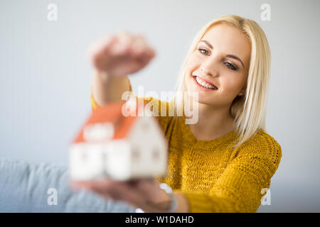Glückliche junge Frau mit nach Hause figurine Home Versicherung Konzept. Stockfoto
