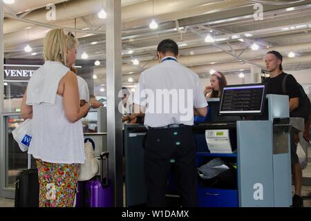 Ryanair Passagiere zahlen über Gebühren für die übergroßen Taschen usw. am Flughafen Athen Griechenland Stockfoto