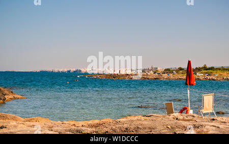 Strand an der Adria, die im Hintergrund der Stadt Polignano im Sommer Sonnenuntergang. Stockfoto