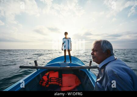 Harte Arbeit am Meer. Zwei Fischer auf dem Boot bei Sonnenaufgang in der Nähe der Küste von Sri Lanka. Stockfoto