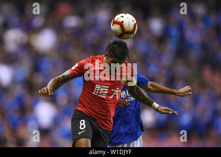 Brasilianische Fußballspieler Paulinho, oben, von Guangzhou Evergrande Taobao leitet den Ball gegen einen Spieler von Shanghai Shenhua Grönland in der 15. Runde während der 2019 chinesischen Fußballverband Super League (CSL) in Shanghai, China, 1. Juli 2019. Guangzhou Evergrande Taobao besiegt Grönland Shanghai Shenhua 3-0. Stockfoto