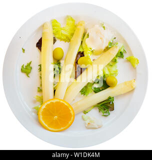 Blick von oben auf die gedämpfte weißer Spargel garniert mit grünen Oliven und Orangen serviert mit traditionellen spanischen Soße allioli. Über weiß backgr Isoliert Stockfoto