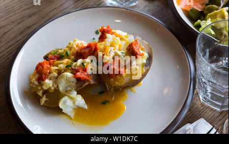 Ember - gebackene Kartoffel mit würzigen Wurst, Pastete und Eier, an Platte im Cafe Stockfoto