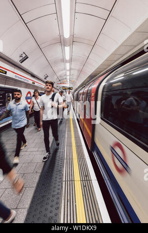 LONDON - 26. JUNI 2019: Personen und Zug auf der Plattform an der Tottenham Court Road U-Bahn Station in London Underground Stockfoto