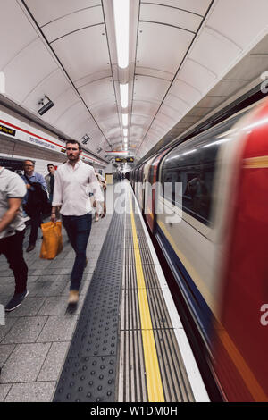 LONDON - 26. JUNI 2019: Personen und Zug auf der Plattform an der Tottenham Court Road U-Bahn Station in London Underground Stockfoto