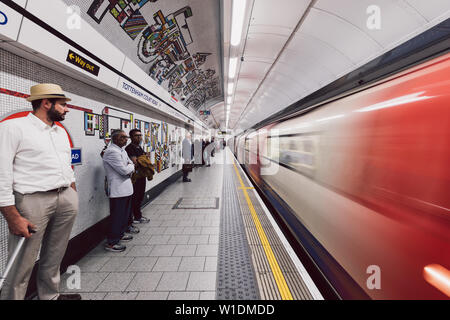 LONDON - 26. JUNI 2019: Personen und Zug auf der Plattform an der Tottenham Court Road U-Bahn Station in London Underground Stockfoto