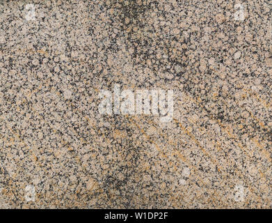 Nahaufnahme einer beschmutzt, Licht rot oder orange und schwarzem Granit stein Wand. Hochauflösende full frame strukturierten Hintergrund. Stockfoto