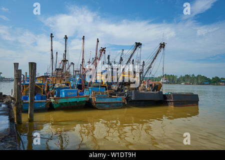 Bunte Fischerboote, die ausgerichtet werden, um an einem Pier am Fluss Kemena in Bintulu, Borneo, Malaysia. Stockfoto