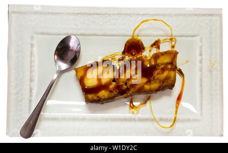 Pan de Calatrava mit Karamell und Löffel, Pudding Kuchen typisches aus Spanien. Auf weissem Hintergrund Stockfoto