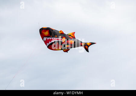 Bedford, Bedfordshire, Großbritannien, Juni 2,2019. Drachen fliegen in den Himmel zwischen den Wolken. Bedford International Kite Festival. Stockfoto