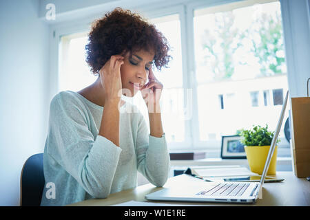 Kopfschmerzen problem - junge Frau mit Laptop Stockfoto