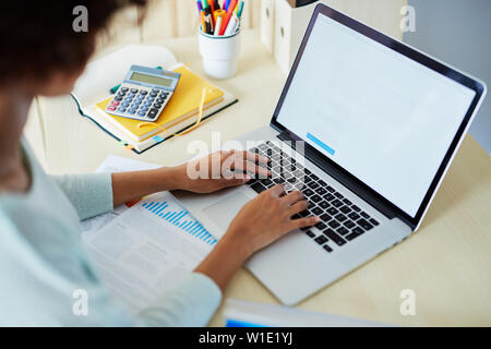 Junge Frau arbeitet sie an ihrem Laptop Schreiben neuer Blogbeitrag Stockfoto