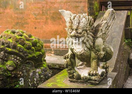 Nahaufnahme eines bemoosten grauen Stein Skulptur von Garuda legendären Vogel bei Ubud Palace. Im traditionellen balinesischen Stil geschnitzt. Stockfoto