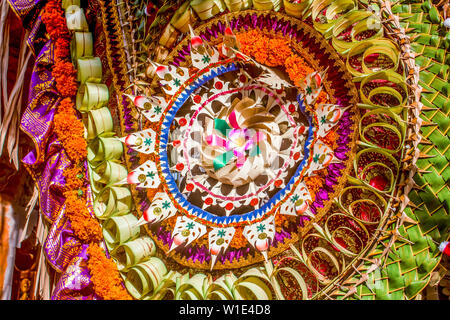 Balinesische bunte und festliche Hochzeit Handwerk Dekoration mit Kokosnuss Blätter, Blüten und Stoff. Ubud Palace Eingang. Stockfoto