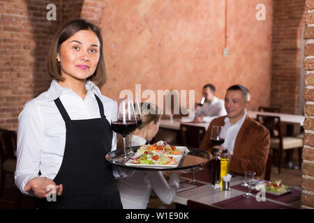 Lächelnde Frau Kellner zeigen Land Restaurant Besucher Stockfoto