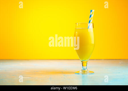 Glas Ananas tropischen frischen Saft auf gelben Hintergrund. Sommer und alkoholfreien Cocktails. Stockfoto