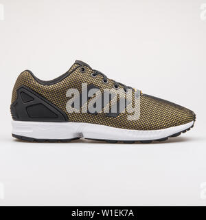 Wien, Österreich - 28. AUGUST 2017: Adidas ZX Flux gold und schwarz Sneaker auf weißem Hintergrund. Stockfoto