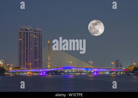 Vollmond in den dunklen Himmel und die Schönheit des Flusses Chao Phraya und die Lichter der Autos auf Pinklao Brücke bei Nacht, Bangkok in Thailand. Stockfoto