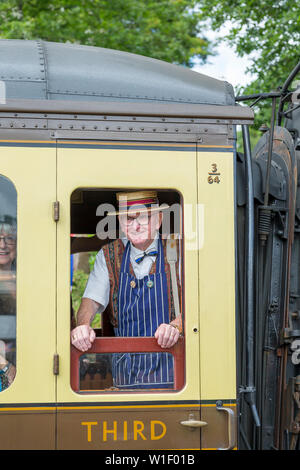 Kidderminster, Großbritannien. Juni 2019. Severn Valley Railways 'Step Back to the 40s' beginnt diesen Sommer mit einem fabelhaften Start mit kostümierten Re-Enactors, die ihre Rolle bei der Bereitstellung einer authentischen Erholung der britischen Kriegszeit des zweiten Weltkriegs spielen. Ein isolierter ranghoher Herr, der als Vintage-Metzger in Strohboater und Schürze gekleidet ist, blickt aus dem Fenster der Dampfeisenbahn. Kredit: Lee Hudson Stockfoto