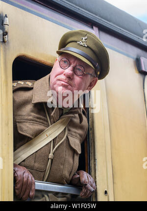 Kidderminster, Großbritannien. Juni 2019. Severn Valley Railways "Step back to the 1940s" startet dieses Wochenende zu einem fabelhaften Start mit kostümierten Re-enactors, die ihren Teil dazu spielen, eine authentische Nachbildung des britischen Krieges zu bieten. Hauptmann Mainwaring Lookalike, in seiner WW2 Home Guard Uniform als Zugkommandant, lehnt sich aus dem alten Eisenbahnwagen, um aus dem Zugfenster zu schauen. Kredit: Lee Hudson Stockfoto