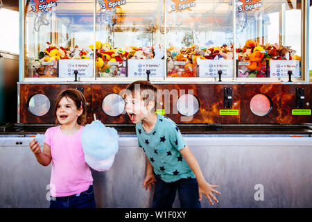 Foto von einem Bruder und Schwester essen eine grosse Zuckerwatte in einem Vergnügungspark. Stockfoto