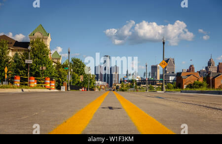 Eine leere Straße durch einen alten Detroit city Nachbarschaft mit der Innenstadt Gebäude im Hintergrund Stockfoto