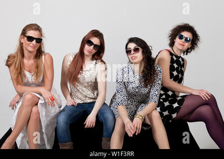 Vier schöne Frauen stellen gemeinsam im Studio Stockfoto