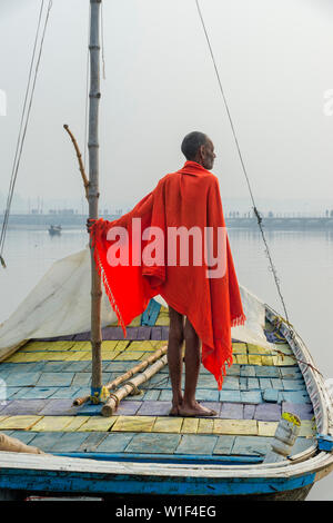 Sadhu mit rotem Schal auf einer Bootsfahrt auf dem Ganges bei Sonnenaufgang, Allahabad Kumbh Mela, der weltweit größte religiöse Versammlung, Uttar Pradesh, Indien Stockfoto