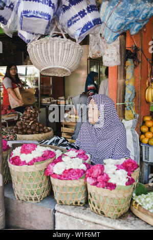 Alte Frau, die Blumen in den traditionellen Markt in Yogyakarta, Indonesien Stockfoto