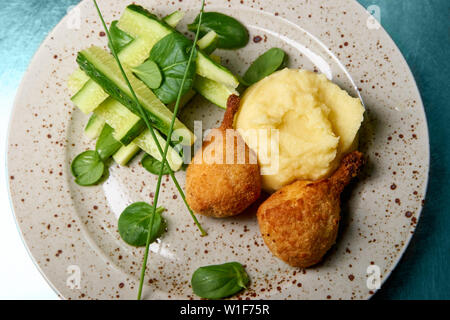 Kartoffelpüree mit knusprigen Hähnchen und Gurken. Stockfoto