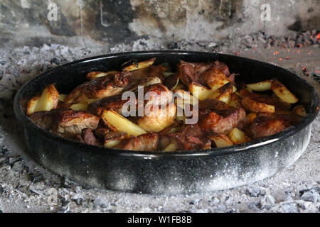 Teller mit Eintopf und Kartoffeln auf dem Grill zubereitet. Stockfoto