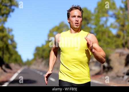 Laufender Mann Sprinten für den Erfolg auf. Männliche Athlet runner Ausbildung bei schneller Geschwindigkeit. Muskulös fit Sport Modell sprinter trainieren Sprint auf der Forststraße. Kaukasische fitness Modell in seiner 20. Stockfoto