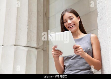 Geschäftsfrau Rechtsanwalt mit Tablet-PC Computer draußen vor Gericht glücklich lächelnd in die Kamera schauen. Schönen jungen gemischten Rennen Kaukasischen/Asiatische Chinesische professionelle Frau. Stockfoto