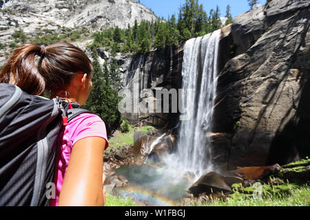 Wanderer Mädchen an Vernal Fall, Yosemite, USA suchen. Natur Landschaft mit Wasserfall im Yosemite National Park, Kalifornien, USA Mit unkenntlich Frau wandern mit Blick auf die Anzeigen. Stockfoto