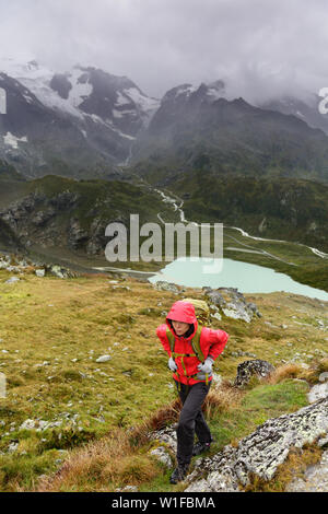 Wandern - Wanderer Frau auf Trek mit Rucksack, gesunden, aktiven Lebensstil. Wanderer Mädchen zu Fuß auf Wanderung in die Berge Natur Landschaft in Fuschertörl, Urner Alpen, Bern, Schweizer Alpen, Schweiz. Stockfoto